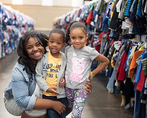 A military husband in camo kisses his military wife, also in camo, at the JBF sale in Tacoma Washington.